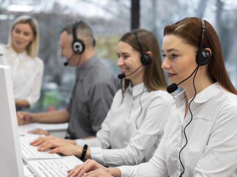 colleagues-working-together-call-center-with-headphones